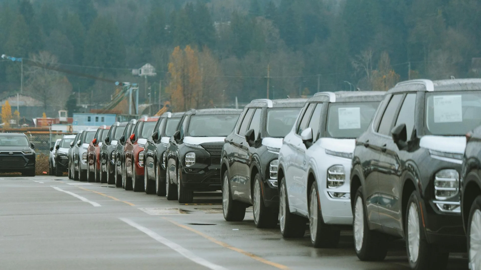 A line of new SUVs parked in an outdoor dealership lot, ready for sale.
