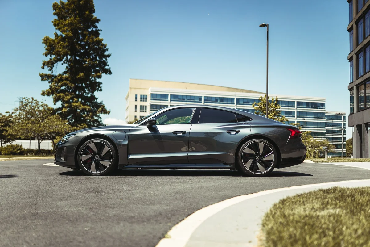 Side view of a sleek luxury car parked outdoors in a modern urban setting.