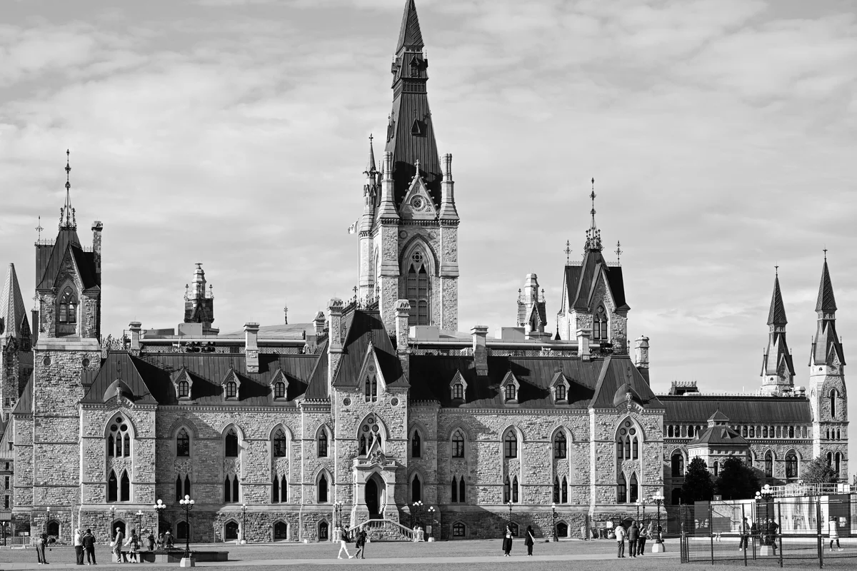 Historic parliament buildings under a cloudy sky