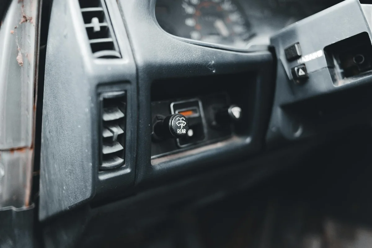Macro shot of a vintage car dashboard with detailed controls and buttons.