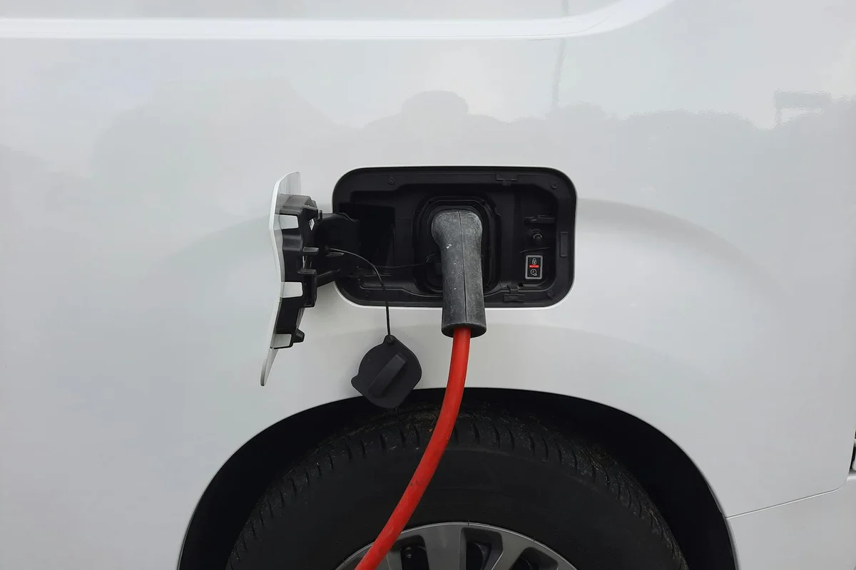 Close-up view of an electric vehicle charging port with a connected charging cable.