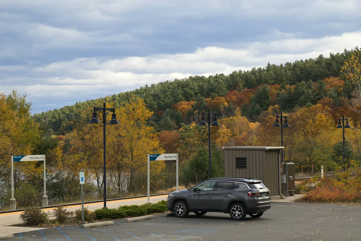 A car parked in a parking lot next to a forest