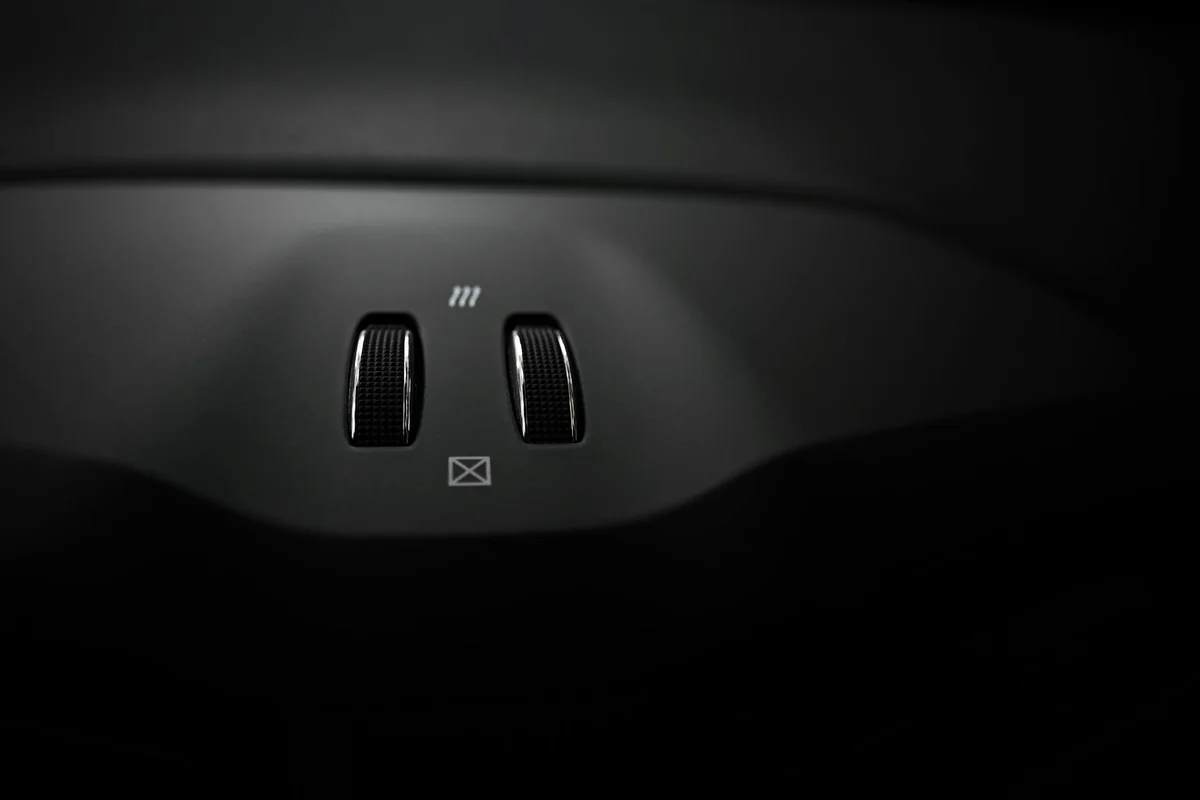 Close-up view of luxury car interior switches with sleek design.