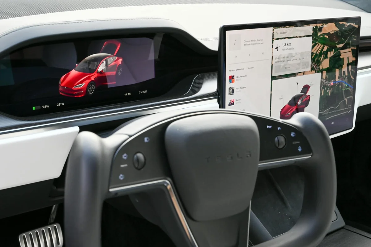 Explore the sleek interior of a modern electric car featuring advanced touchscreens and innovative steering design.