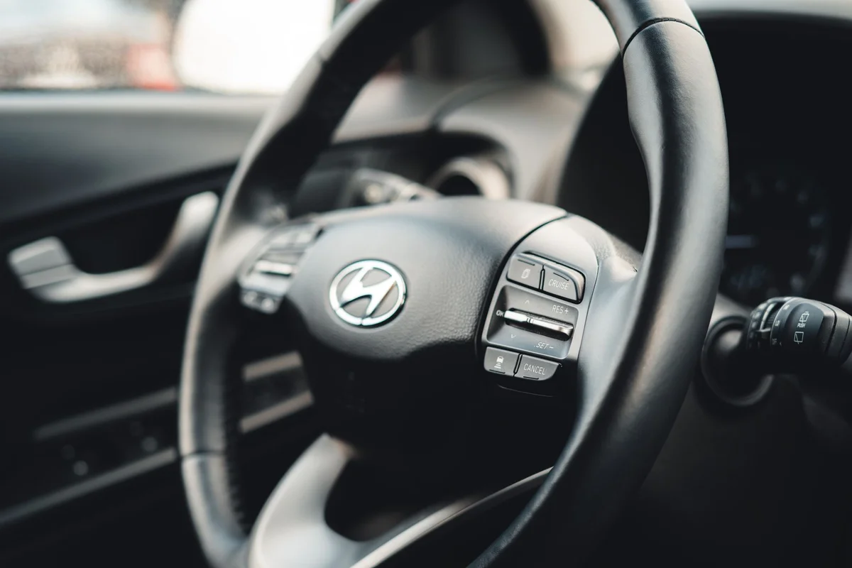 Close-up view of the car steering wheel showcasing interior design details.