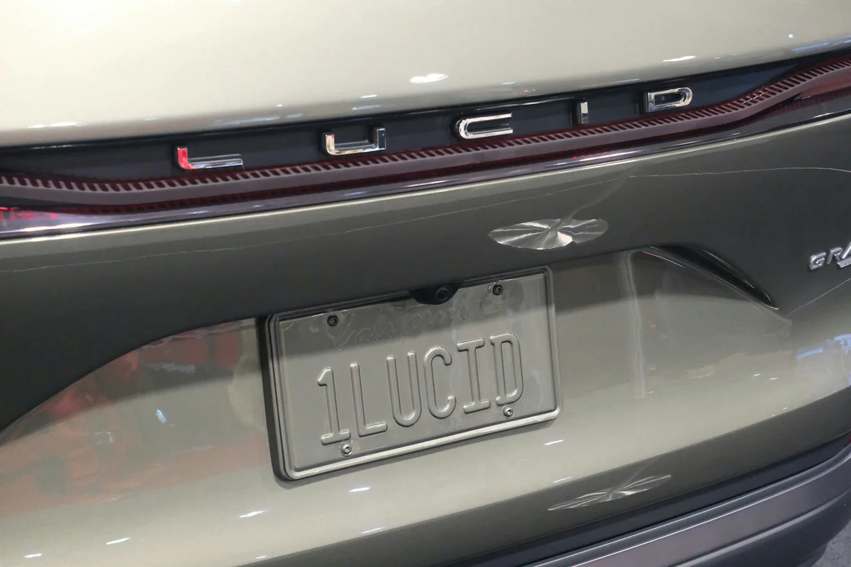 The rear of a light green Lucid car with a "1LUCID" license plate.
