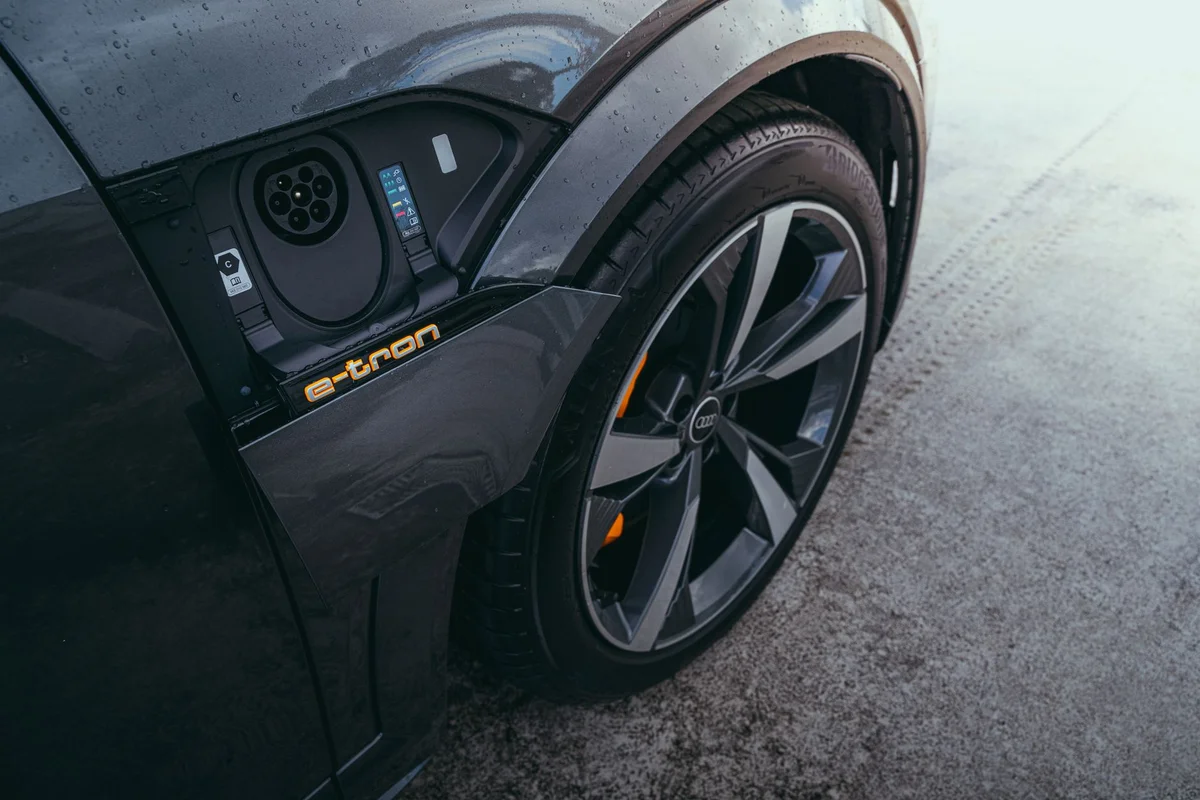 Detailed view of an electric car's charging port and wheel, captured in Curitiba, Brazil.