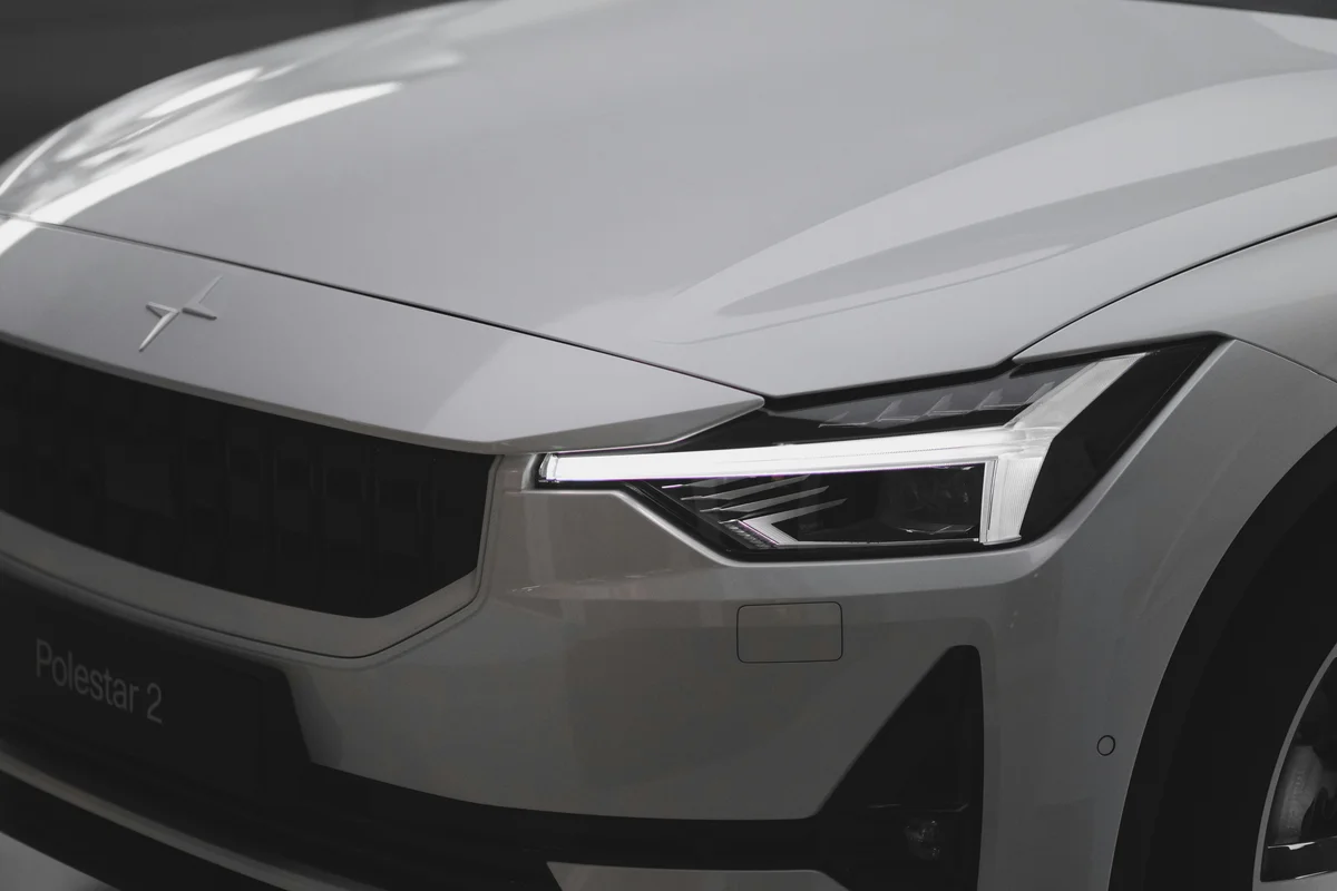 The front of a silver car with a black background