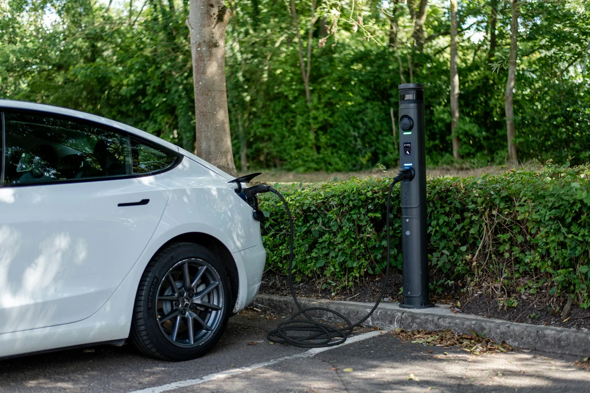 White electric car plugged in at a charging station