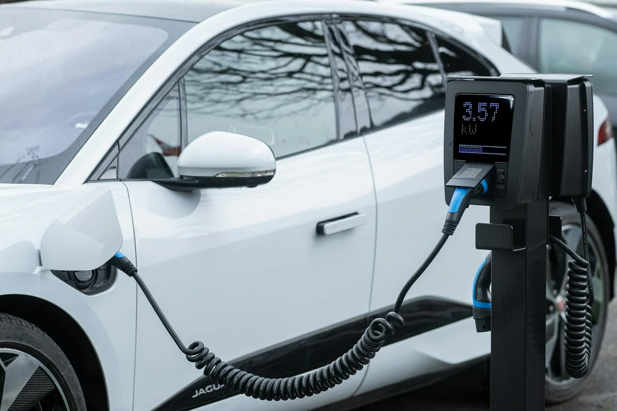 Close-up of an electric vehicle charging at a station, showcasing energy-efficient technology.