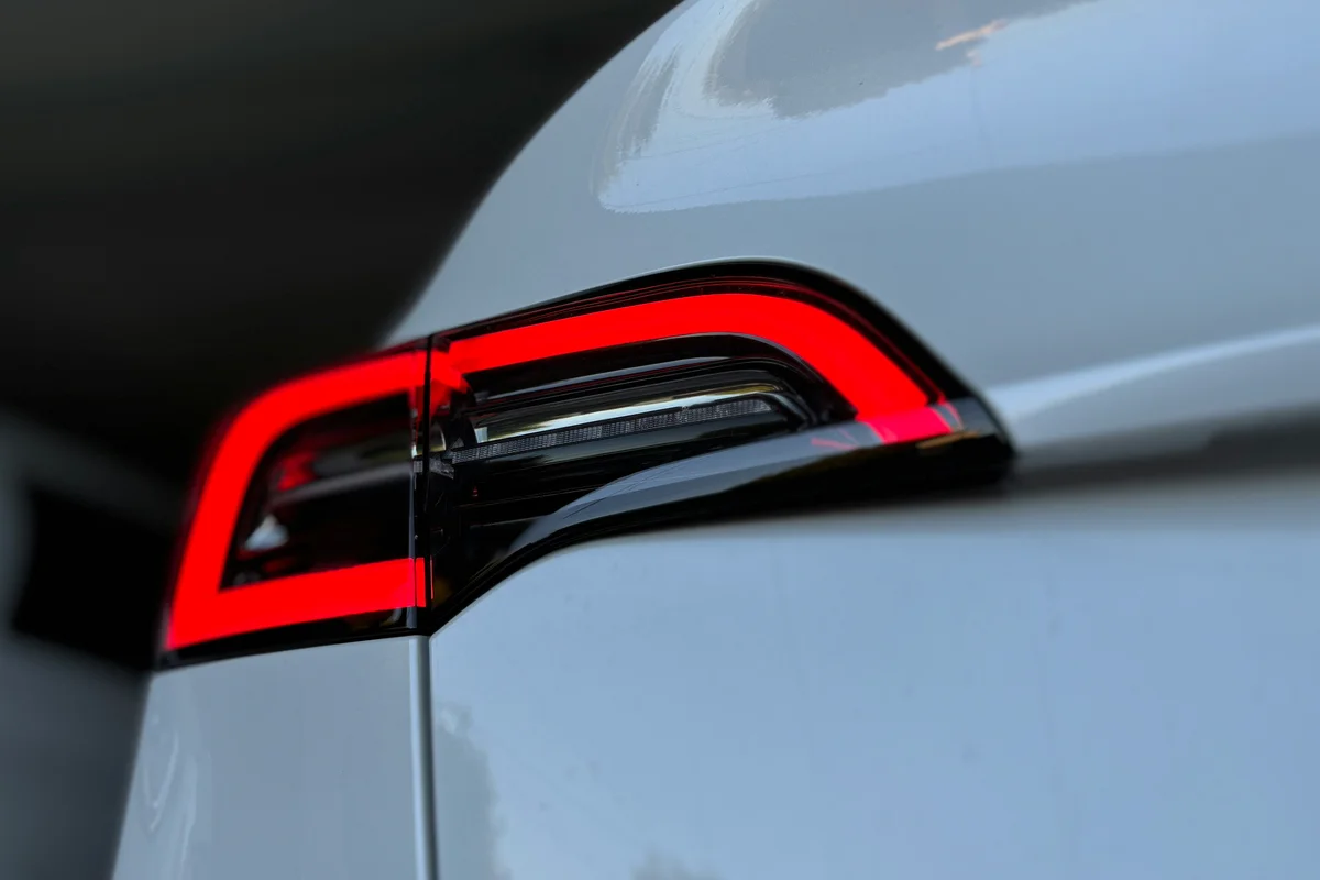 The image shows a white car's tail light.