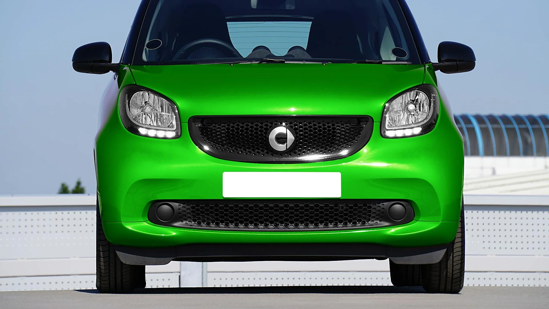The front of a silver truck with a white light bar across the top and a black bumper below.