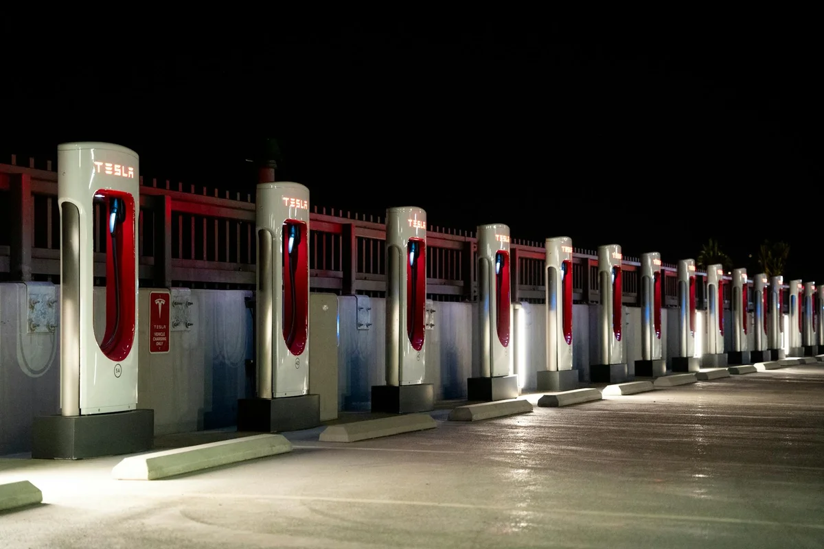 A row of Tesla charging stations illuminated at night in Redlands, CA.