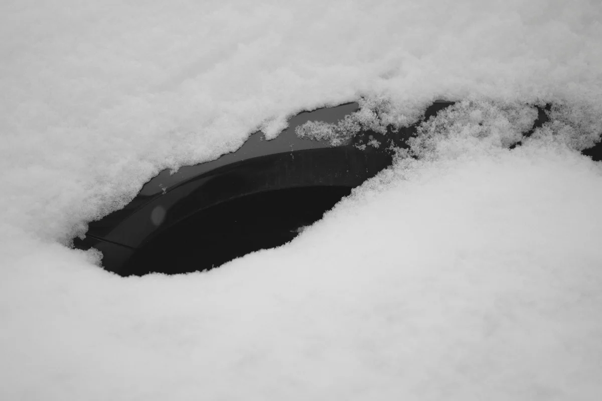 A car covered in thick snow during winter